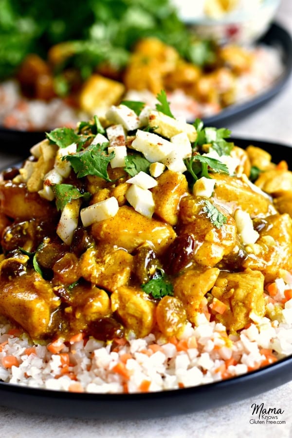 Gluten-Free Turmeric Coconut Chicken Curry on a plate with cauliflower rice with another serving in the background