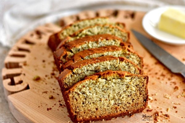 Gluten-Free Banana Bread slices on a cutting board with a knife and butter