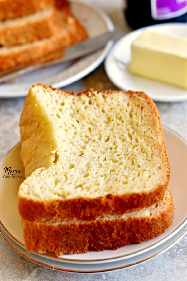 Gluten-Free bread slices on a plate with butter and jelly in the background.