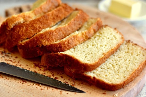 loaf of gluten-free bread sliced on a cutting board with a knife