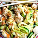 honey lemon ginger chicken zoodles in a bowl with lemon slices and chopsticks