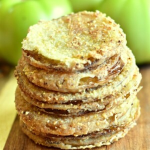 a stack of gluten-free fried green tomatoes with green tomatoes in the background