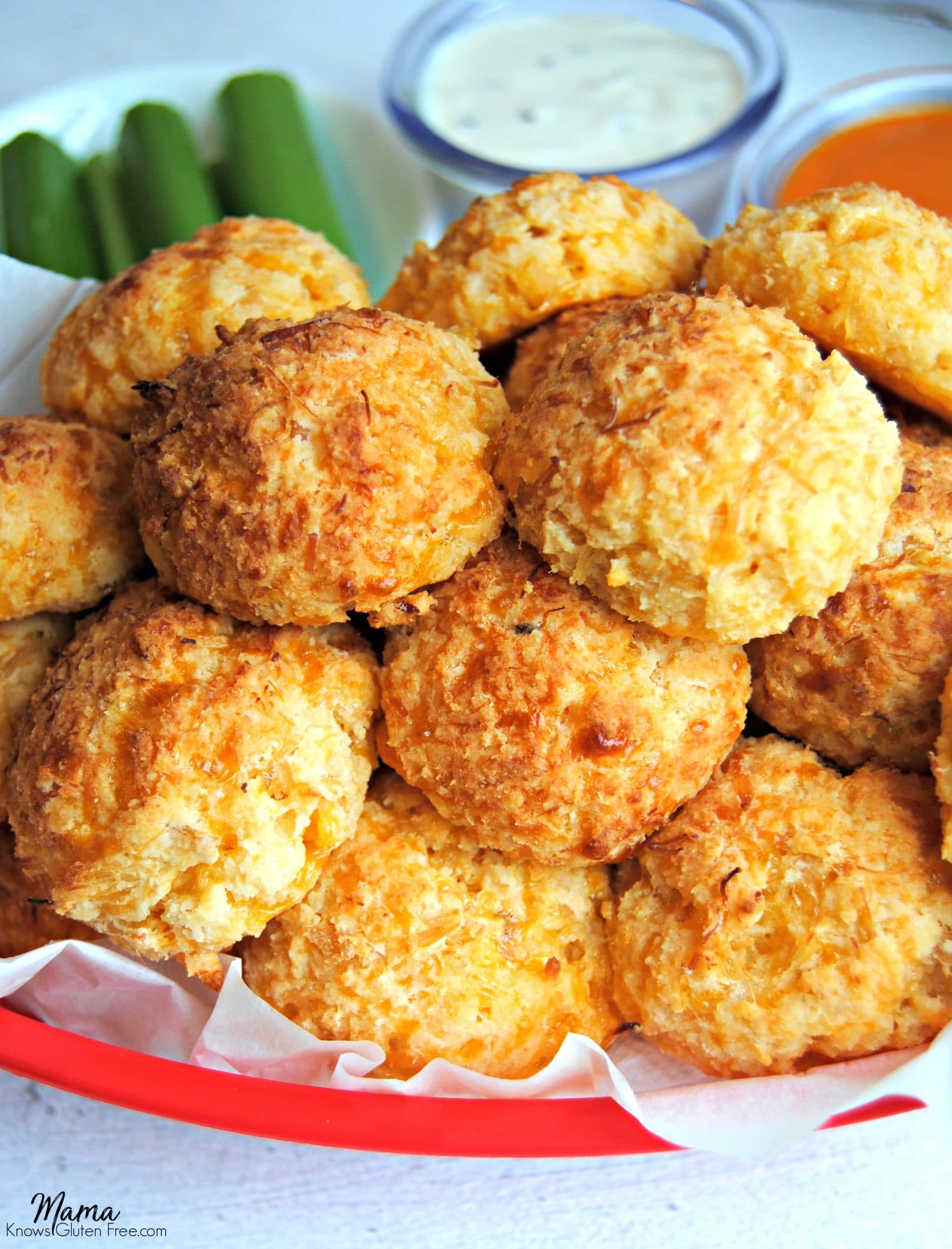 gluten-free buffalo chicken bites in a red basket with celery and sauce