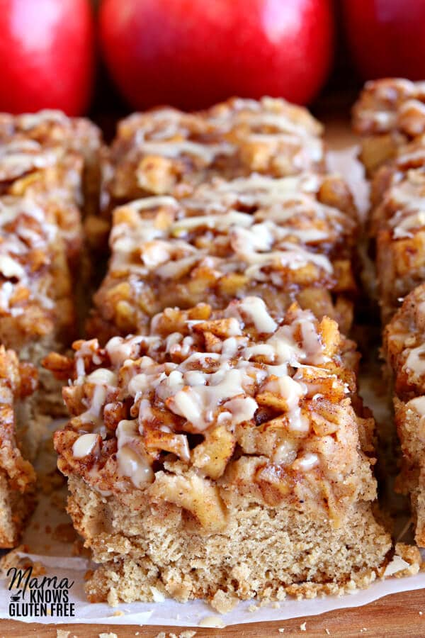 gluten-free apple pie blondies with red apples in the back ground.