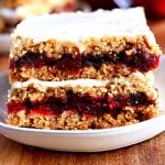 gluten-free cranberry bars on a white plate with cranberries in the background.