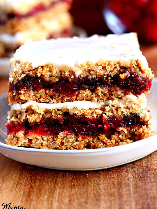 gluten-free cranberry bars on a white plate with cranberries in the background.