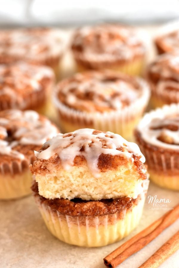 cinnamon roll muffin cut in half to show the texture with cinnamon roll muffins and cinnamon sticks