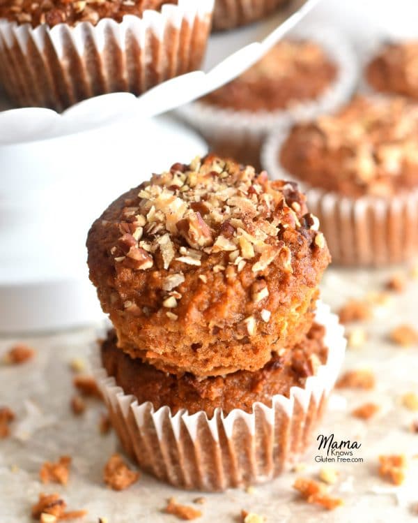 two Paleo carrot cake muffins stacked on top of each other with more muffins in the background