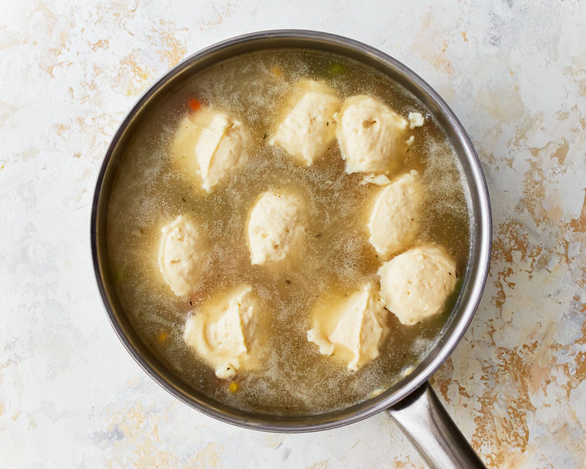 Gluten-free dumplings simmering in a pan