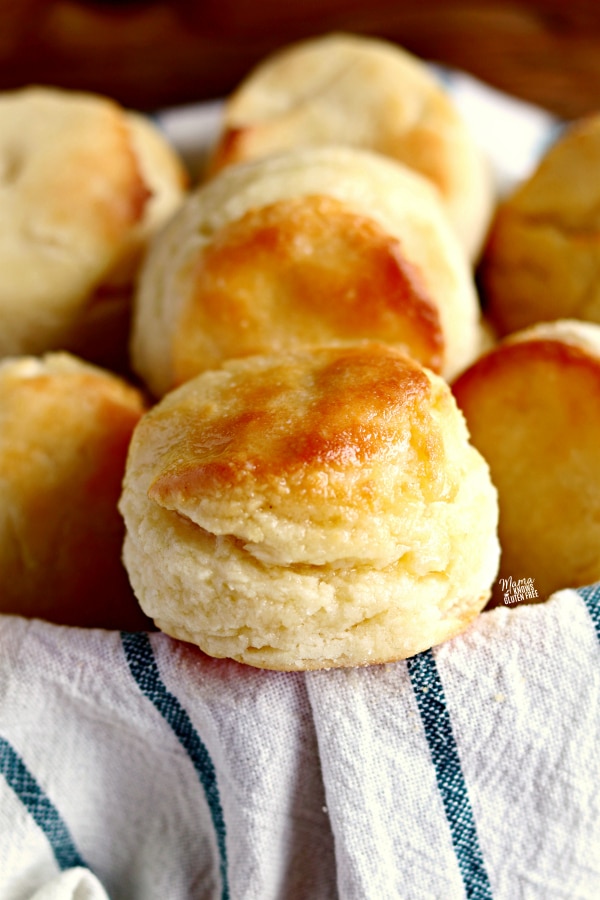 gluten-free biscuits in a basket with a white and blue kitchen towel
