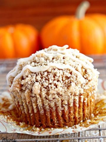 gluten-free pumpkin crumb muffin muffin on a cooling rack with pumpkins in the background