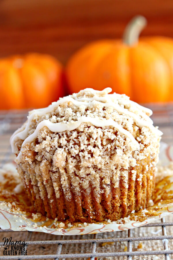 gluten-free pumpkin crumb muffin muffin on a cooling rack with pumpkins in the background