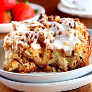 gluten-free french toast casserole on a white plate with coffee and strawberries in the background