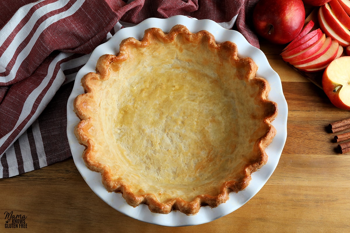 gluten-free pie crust that is baked with apples and a red kitchen towel in the background