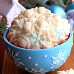 blue snowflake bowl of gluten-free almond spritz cookies with Christmas decorations in the background
