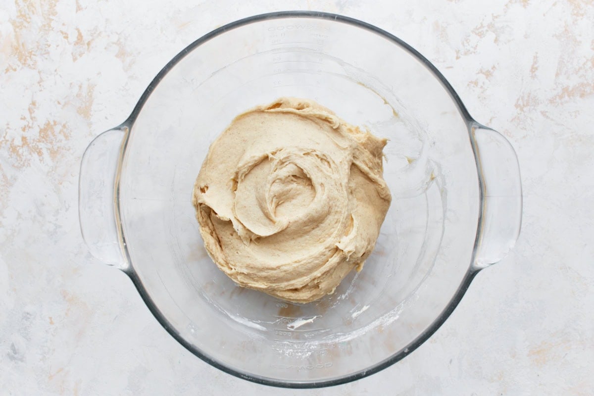 Gluten-free dinner roll dough in a glass bowl.