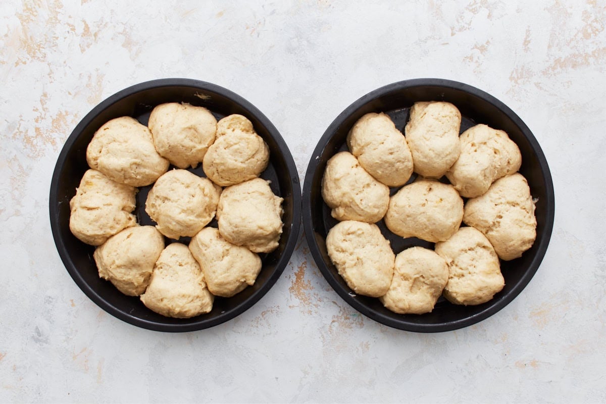 Gluten-free dinner roll dough after proofing in two cake pans.