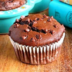 gluten-free chocolate muffin with books, muffins and coffee cup in the background