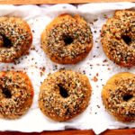 gluten-free bagels on parchment paper on a wood serving tray