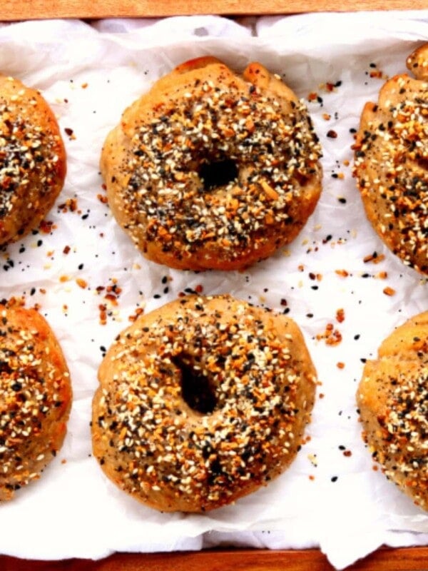 gluten-free bagels on parchment paper on a wood serving tray