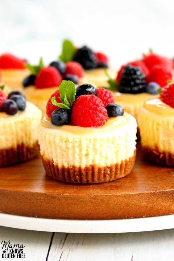 zoomed in shot of gluten-free min cheesecakes topped with lemon curd and berries