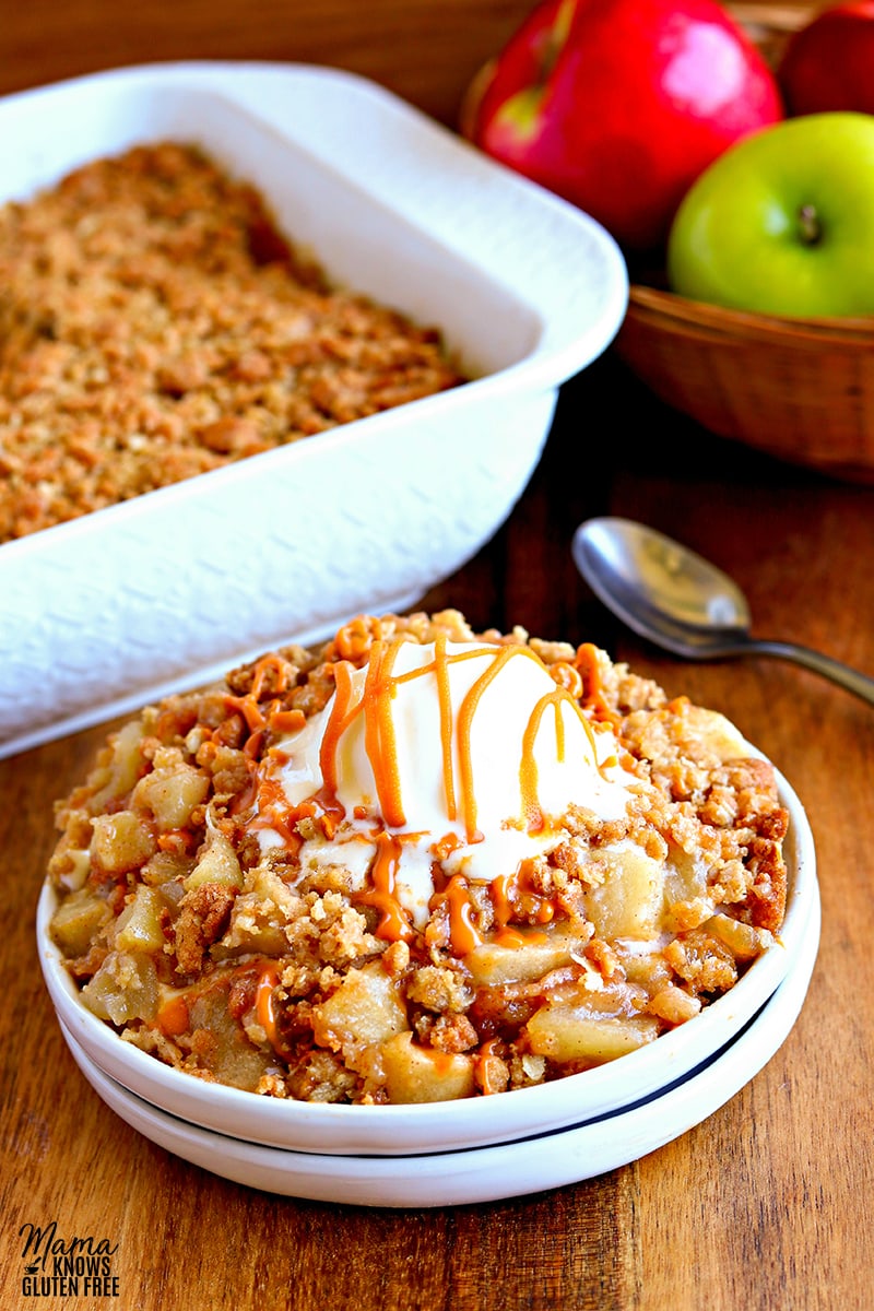 gluten-free apple crisp served on a white plate with the apple crisp and apples in the background