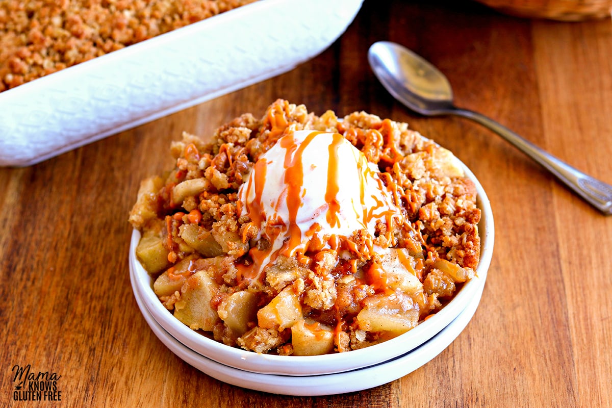 gluten-free apple crisp on a while plate topped with ice cream 