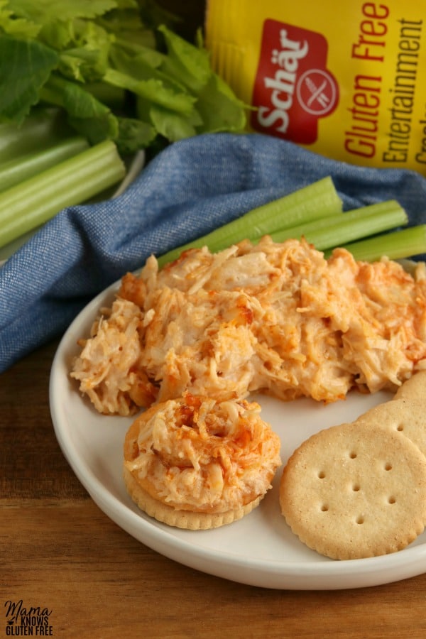 a plate wiht crackers, celery and buffalo chicken dip 