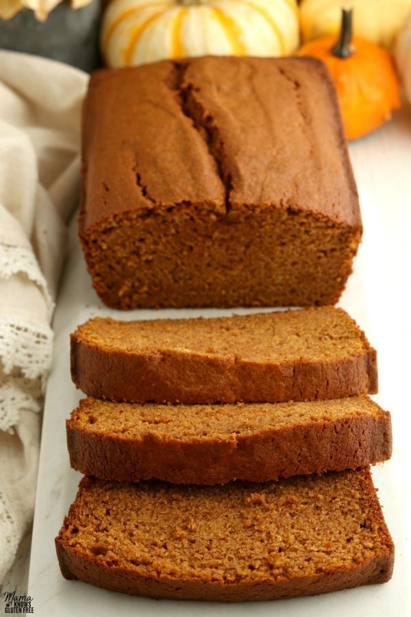 loaf of gluten-free pumpkin bread with 3 slices cut out of it