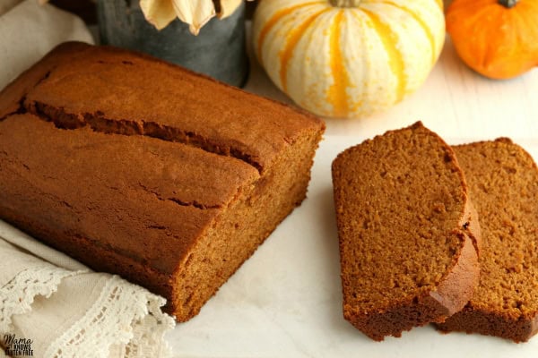 gluten-free pumpkin bread with two slices and pumpkins in the background