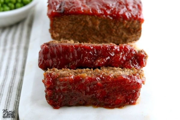 a gluten-free meatloaf with two slices cut into it on a white platter