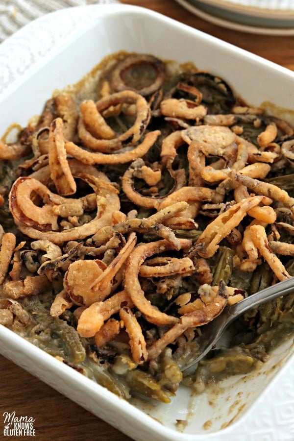 white casserole dish with gluten-free green bean casserole and a serving spoon