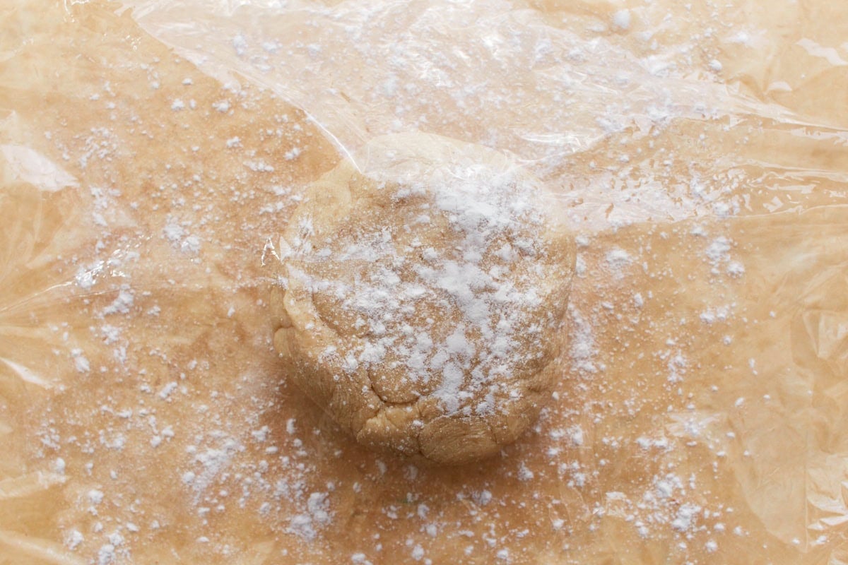A ball of gluten-free pie crust dough sprinkled with flour.