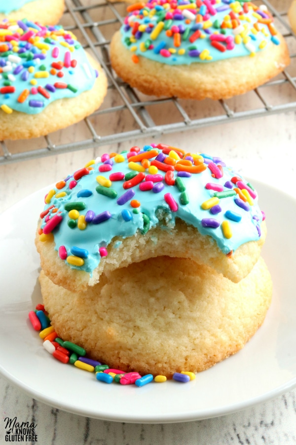 gluten-free sugar cookie with bite out of it to show the texture with more cookies in the back ground