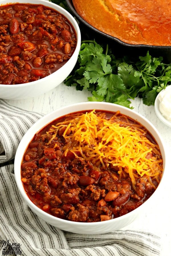 2 bowls of gluten-free chili with cornbread and clintro in the background