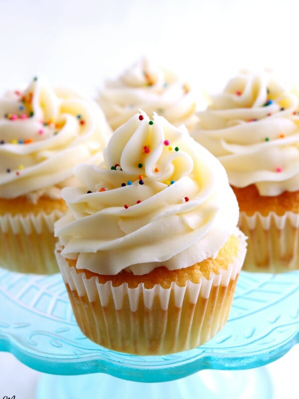 4 gluten-free vanilla cupcakes on a blue cake plate