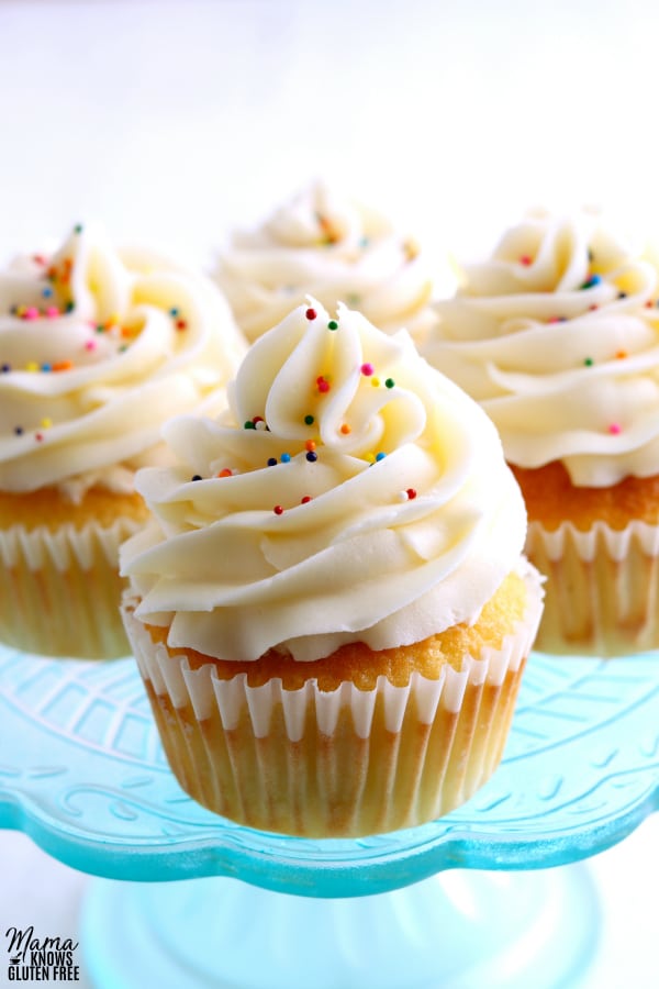 4 gluten-free vanilla cupcakes on a blue cake plate