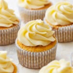 frosted gluten-free vanilla cupcakes in cupcake liners.