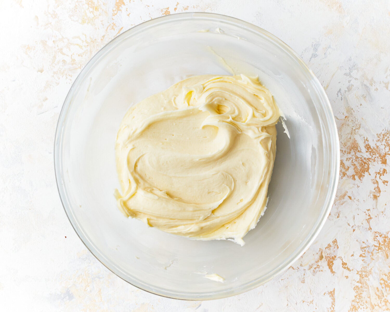 beaten frosting in a glass bowl.