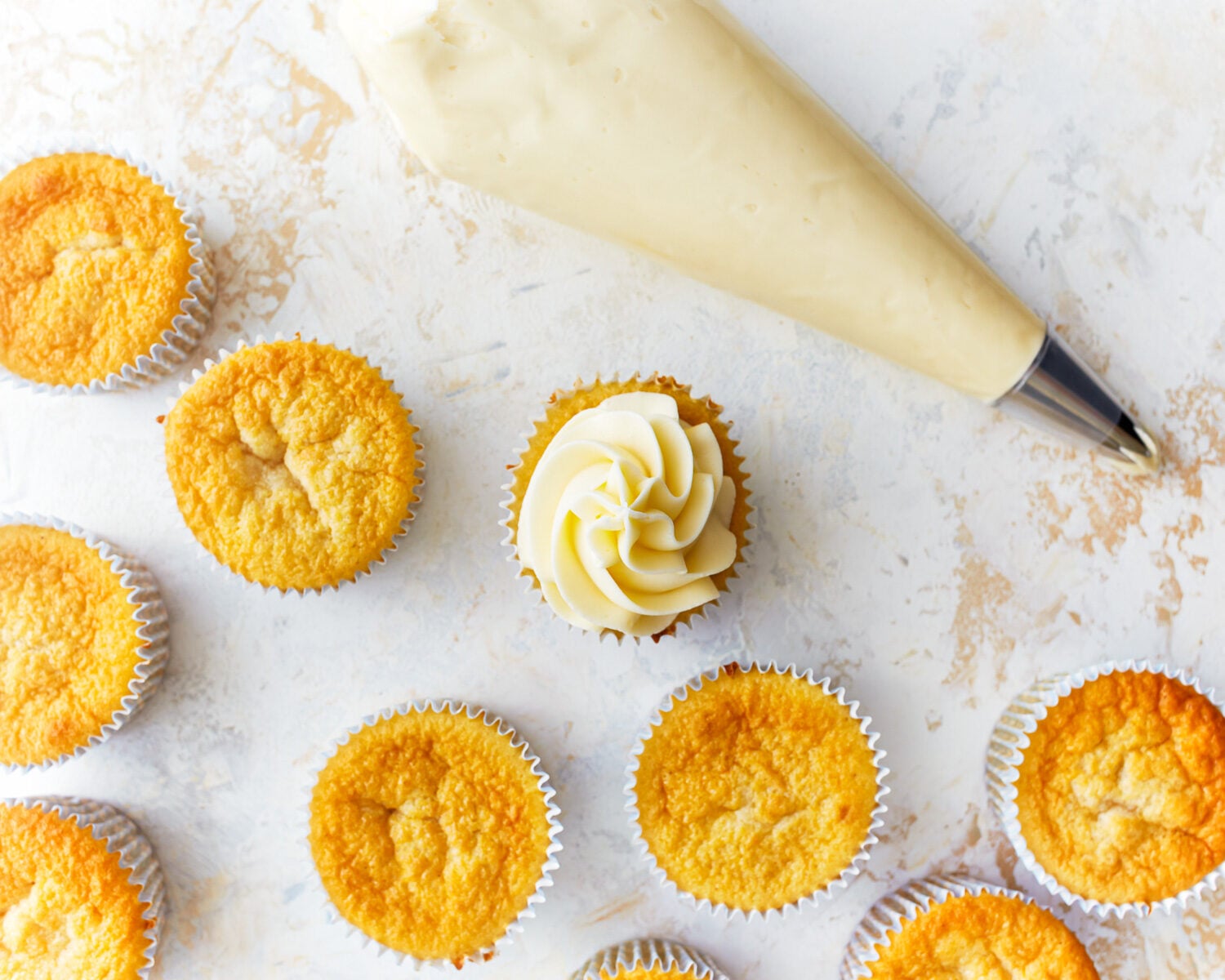 frosting gluten-free vanilla cupcakes.