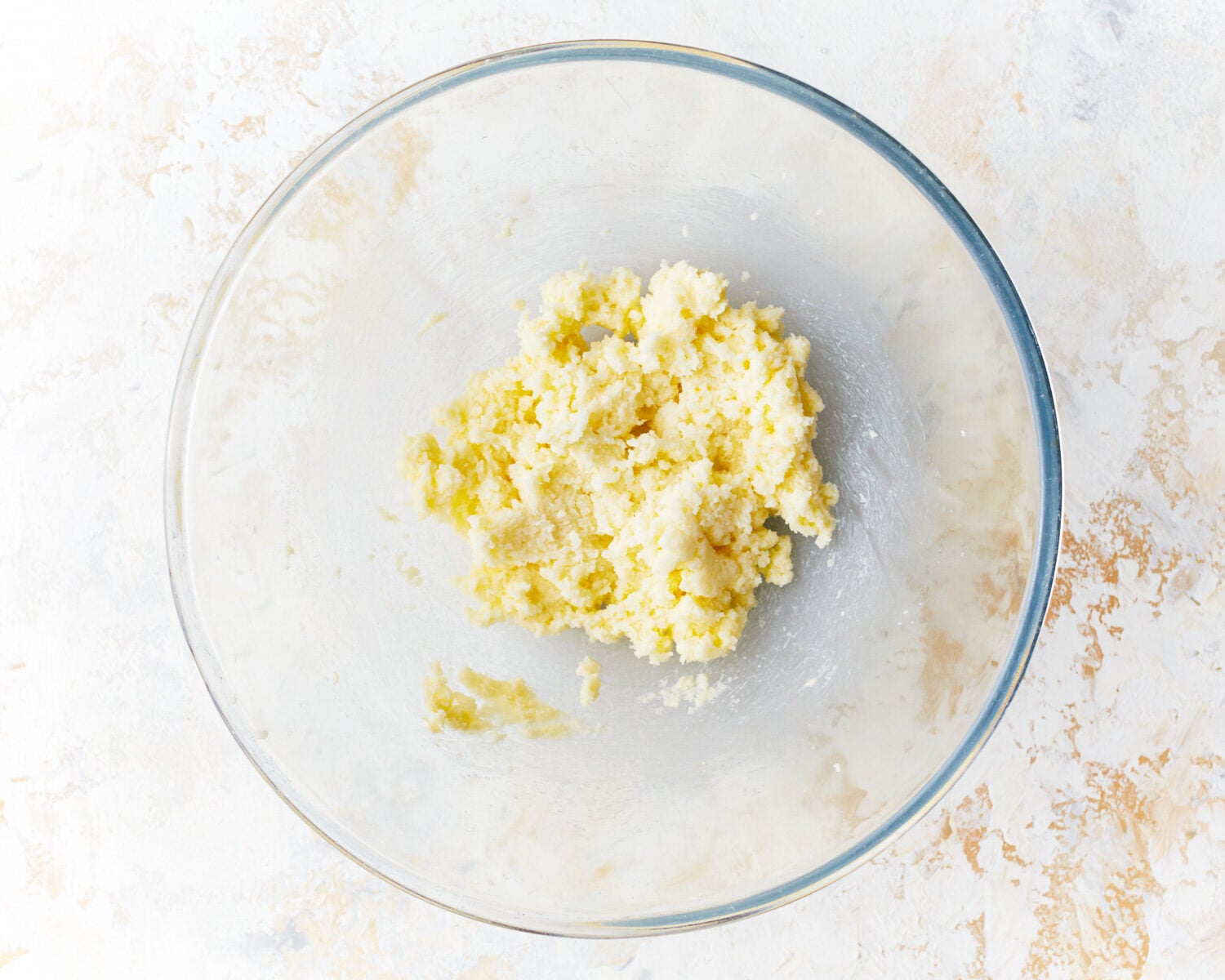 beating butter in a glass bowl.