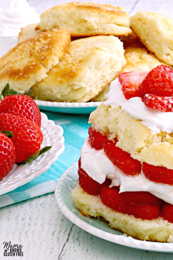 gluten-free strawberry shortcake with strawberries and more shortcakes on a plate in the background