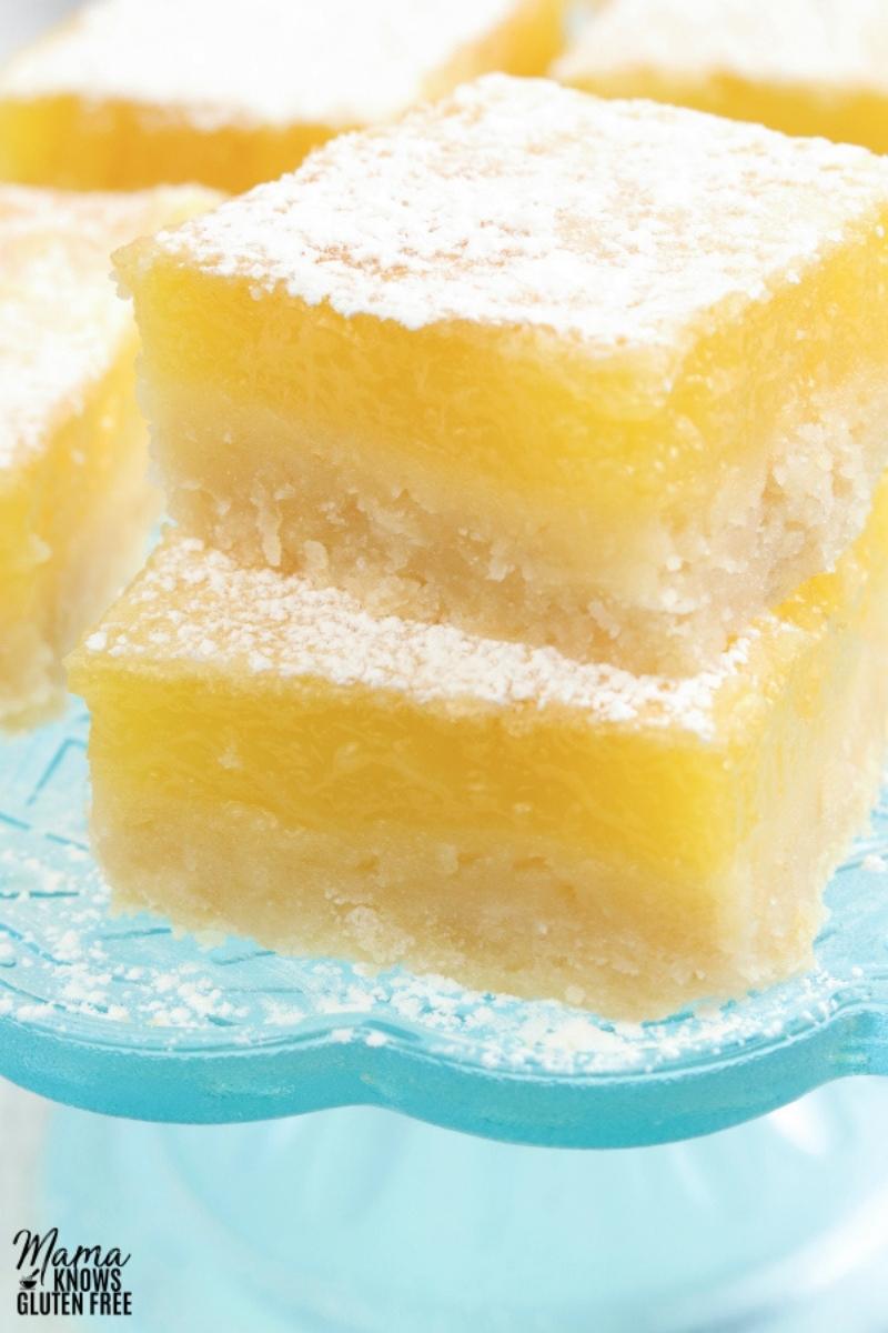 gluten-free lemon bars stacked on a blue cake plate