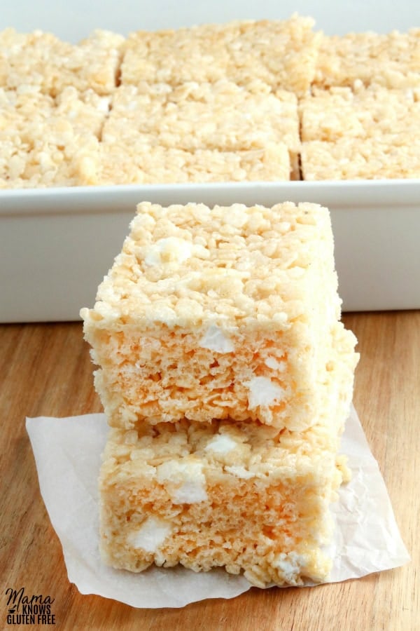 gluten-free rice krispies treats stacked on top of each other with the pan in the background