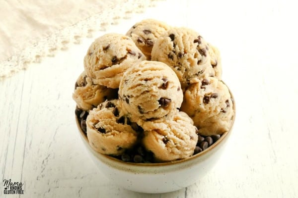 gluten-free cookie dough bites in a white bowl with a cream napkin behind it