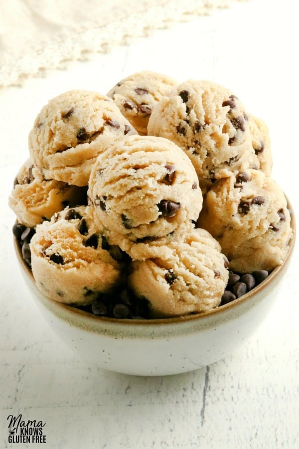 gluten-free cookie dough in a white bowl with cream napkin in the background