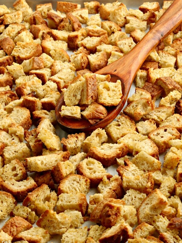 gluten-free crouotns on a baking sheet with a wooden spoon