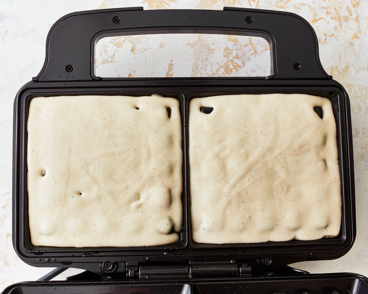 gluten-free waffle batter in a waffle iron.