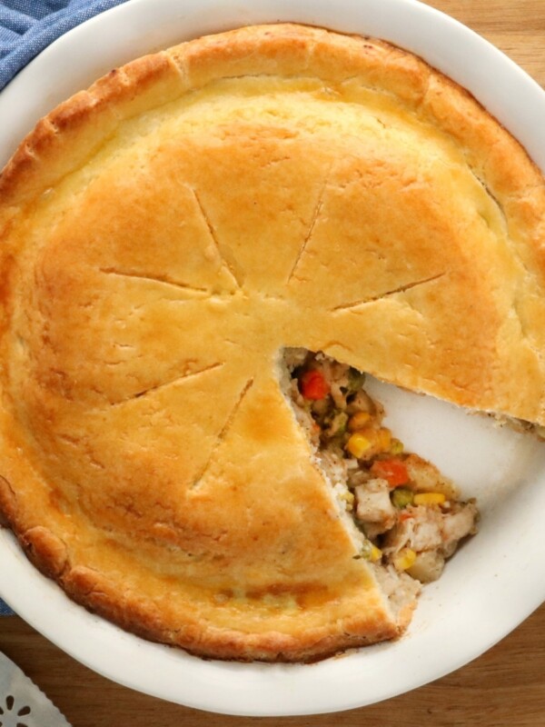 gluten-free chicken pot pie with slice cut out of it with blue napkin and pie cutter