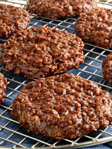 gluten-free no-bake cookies on a cooling rack with a blue kitchen towel underneath